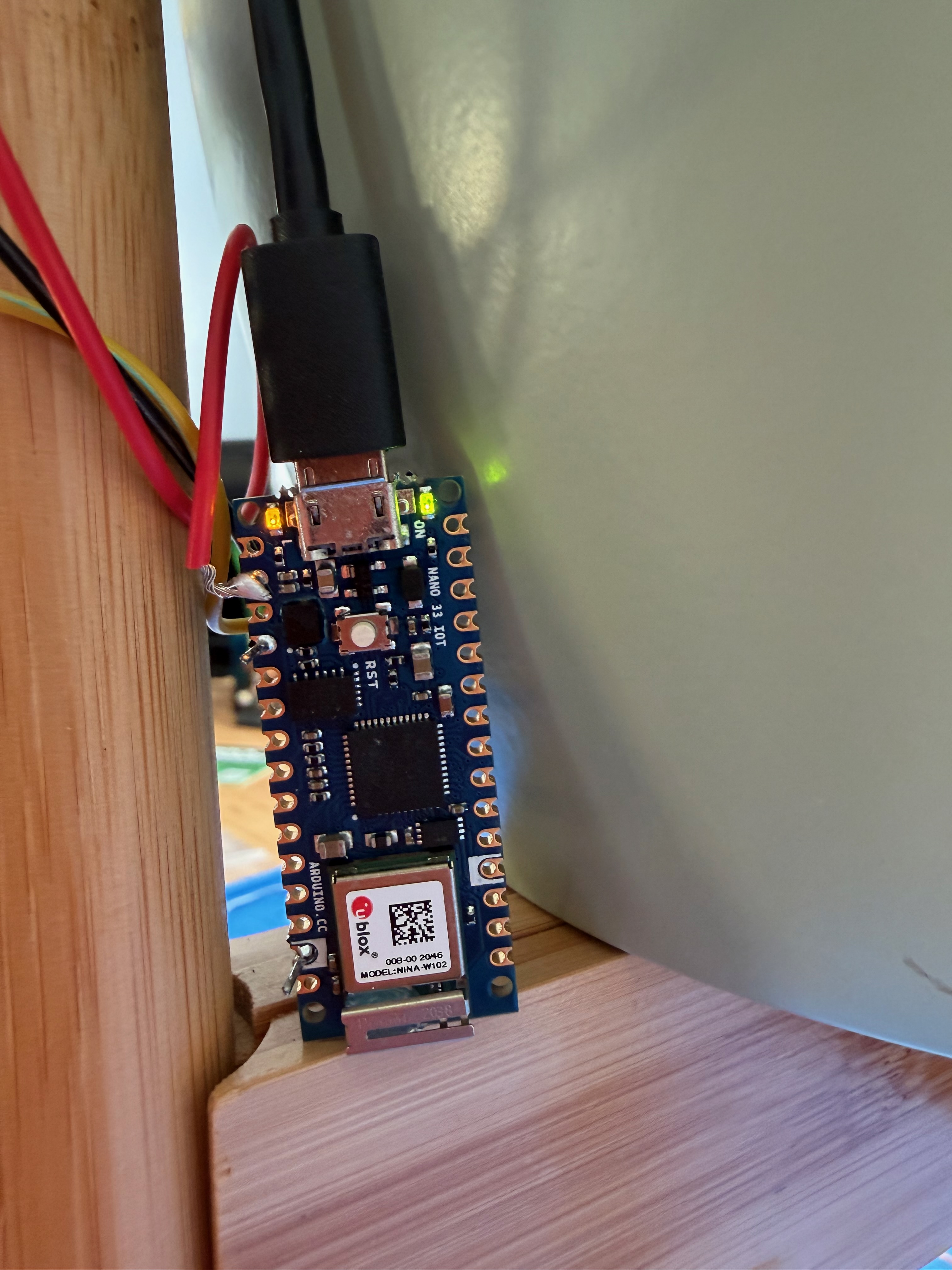 Arduino Nano board close up with power light in green and built in LED lit up orange to show when soil is dry